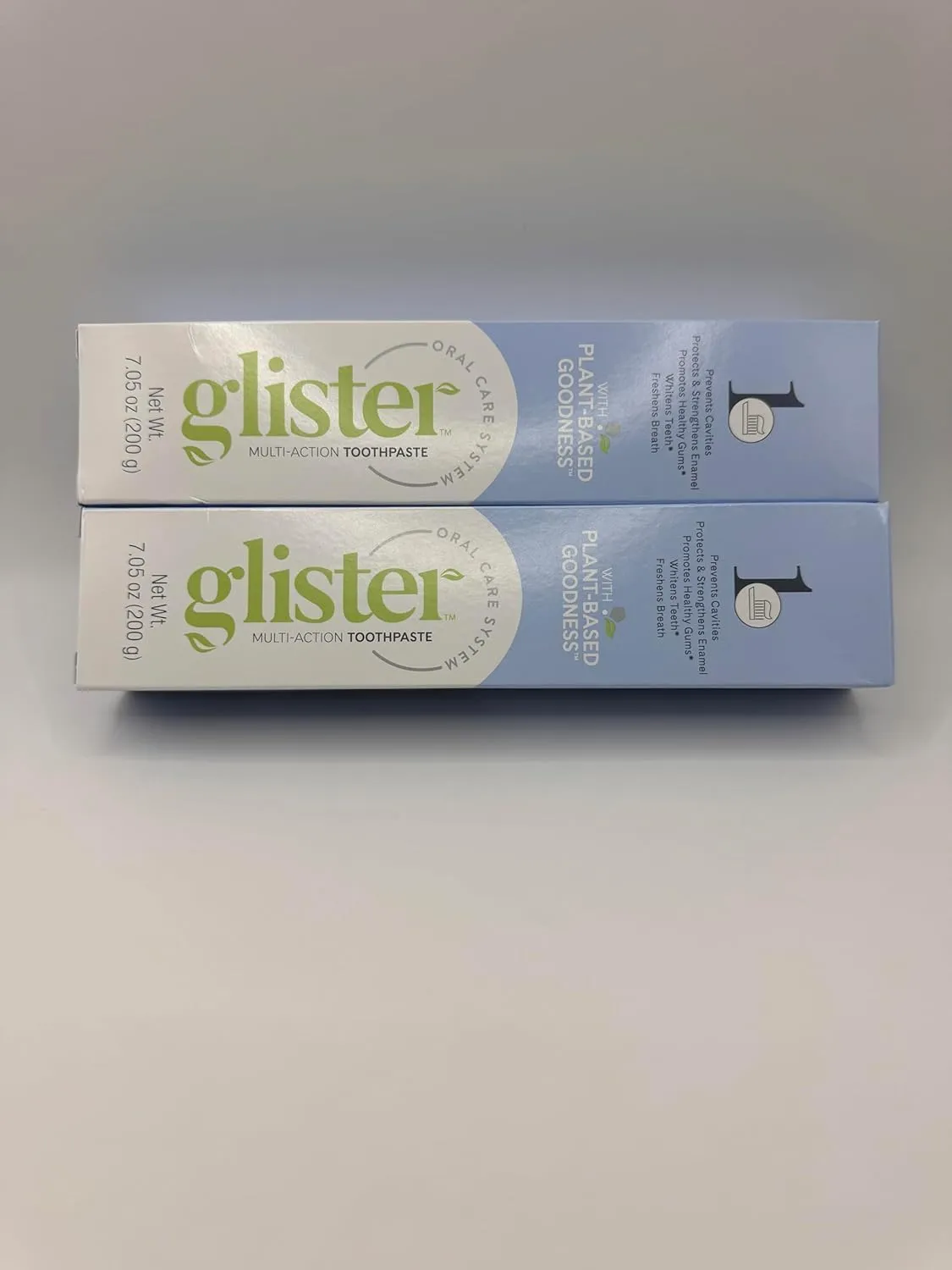 Glister Multi-Action Toothpaste, Pack of 2 (7.05 oz Each), with 2 Toothbrushes.